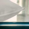 Gros plan sur une taie d'oreiller en polypropylène blanc avec fermeture éclair, sur fond de fenêtre