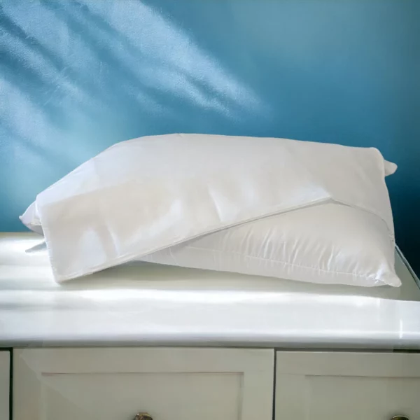 Taie d'oreiller en polypropylène blanc reposant sur un lit d'hôtel avec fond bleu