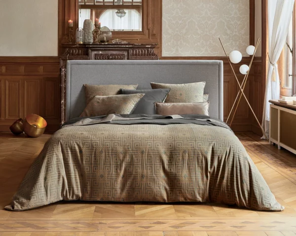 Chambre classique avec housse de couette en satin jacquard Trianon dans des tons beige et gris, reflétant une élégance intemporelle.