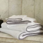 Linge de bain Fjord blanc avec point de cheval posé sur une étagère en marbre
