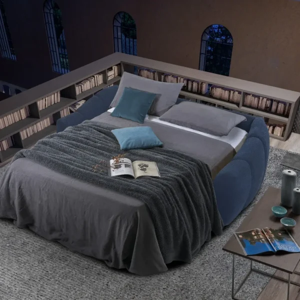 Canapé convertible Nuvola ouvert révélant un lit spacieux avec couette grise et oreillers dans une chambre.