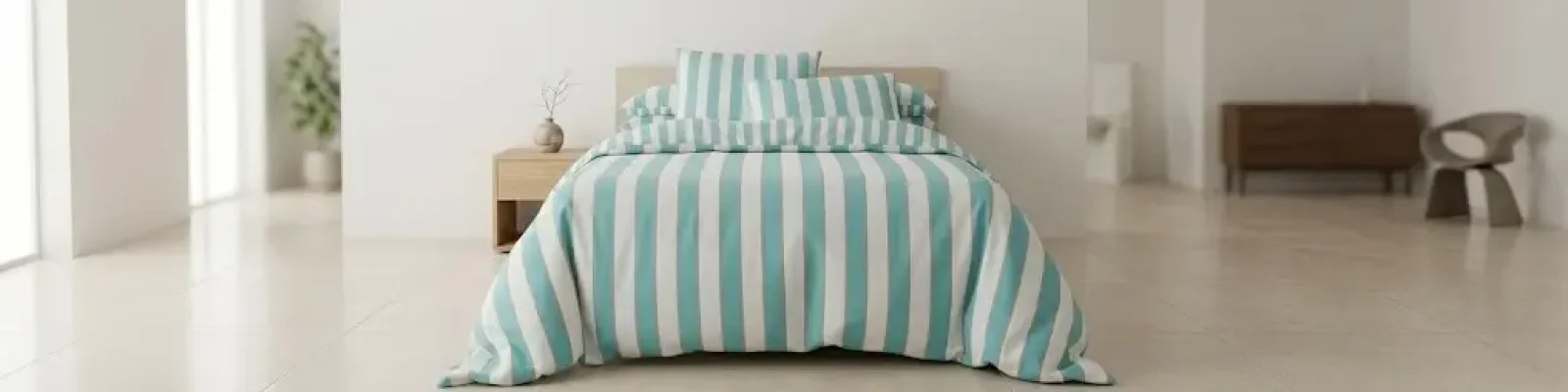 Parure de lit rayée bleu et blanc sur un lit dans une chambre élégante et lumineuse